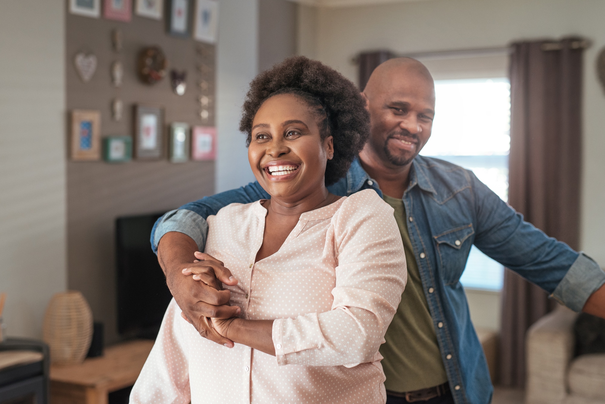 Allograft Surgery Columbus OH Affectionate mature African couple laughing and enjoying a playful moment while dancing together in their living room at home