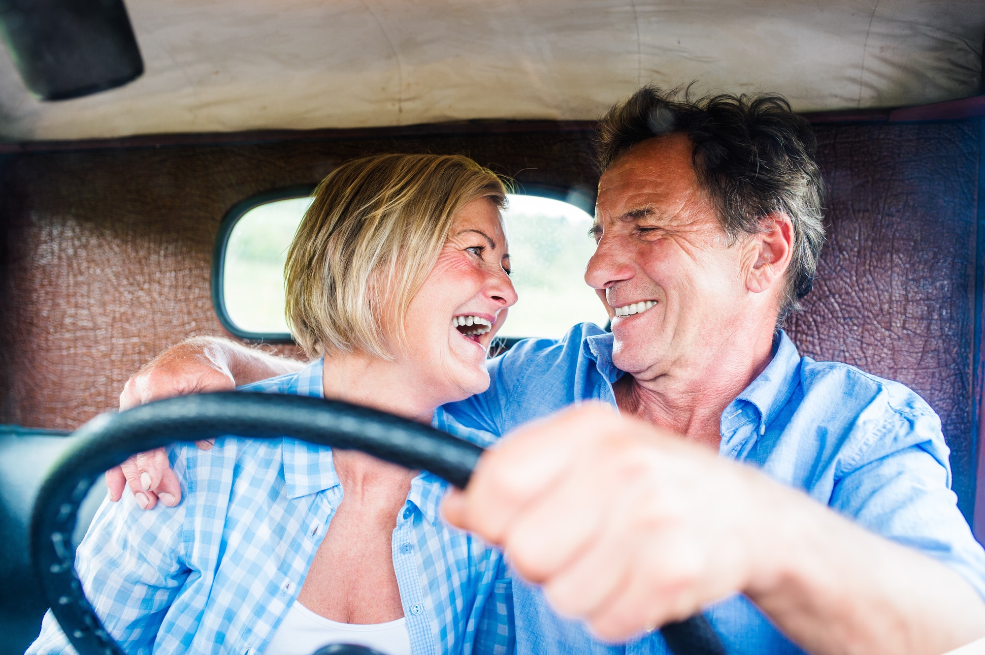 Senior couple in their vintage red car